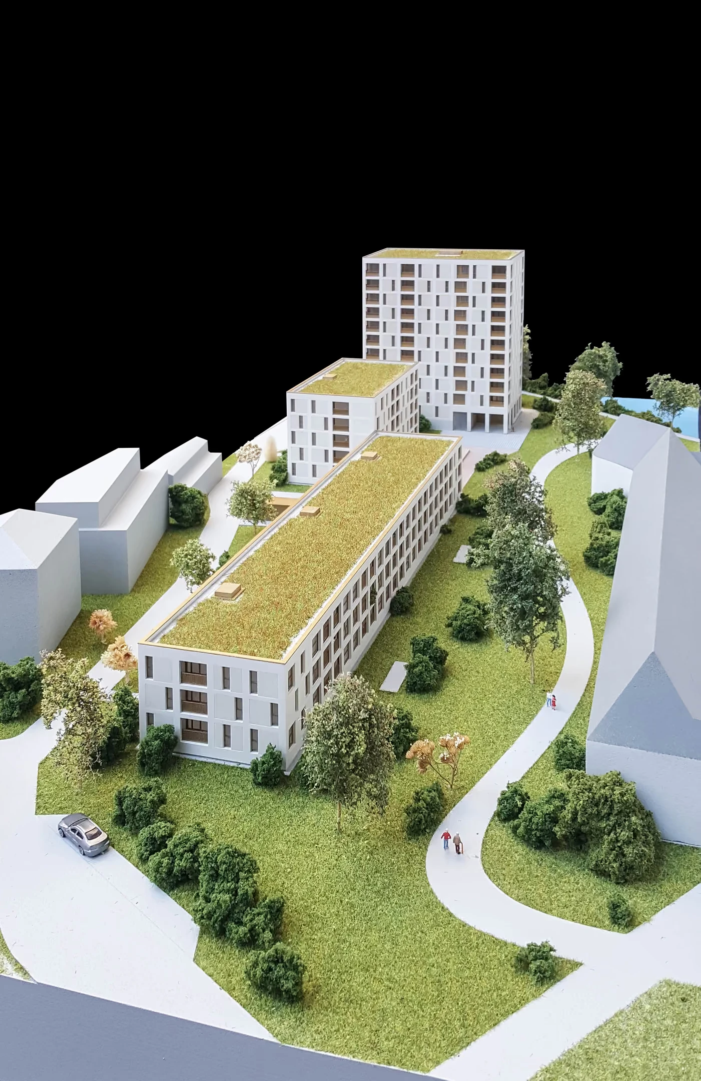 Hochformatiges Stadtmodell mit begrüntem Dach, Bestandshäusern und angelegten Wegen.