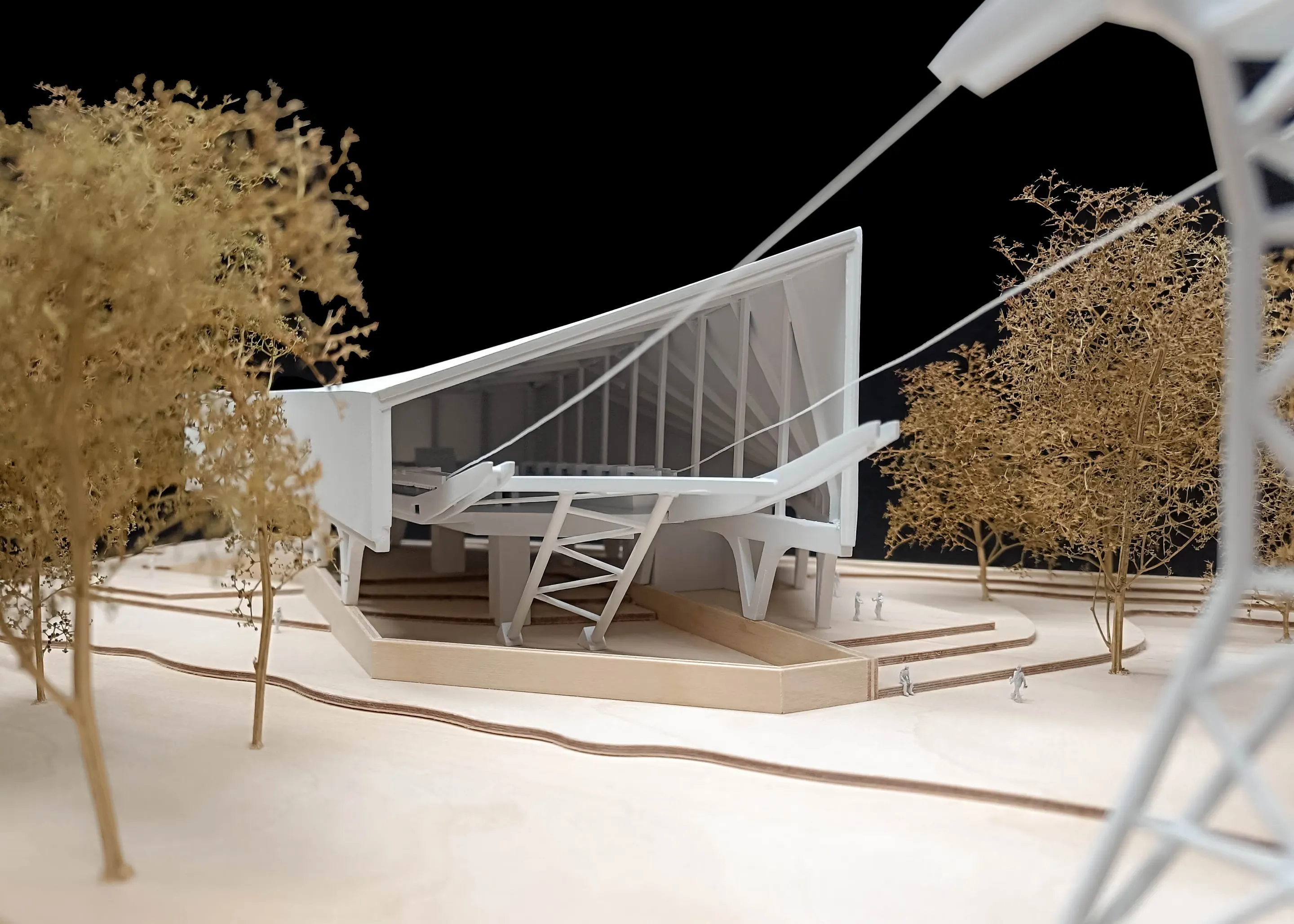 Modell einer Seilbahnstation mit gespannten Tragseilen, Treppenanlage und Herbstbäumen.